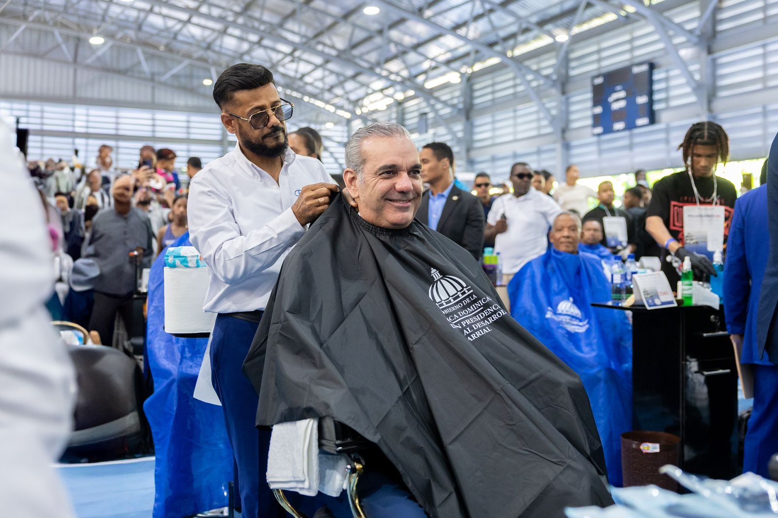 Presidente Abinader sostiene encuentro nacional con 1,000 peluqueros y recibe recorte de cabello durante jornada social